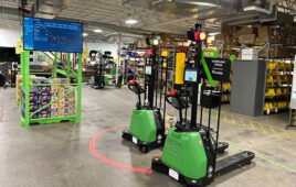 Indoor industrial facility with autonomous mobile robots operating among warehouse shelving and equipment.